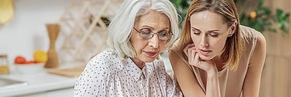 a photo of a senior woman with her daughter administering a deceased estate on a laptop